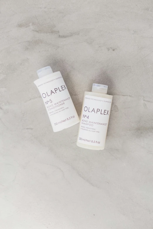 2 tubes of creams sitting on top of a gray marble floor