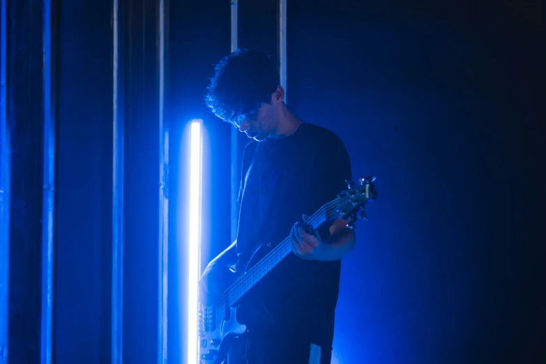 a man playing a guitar in the dark