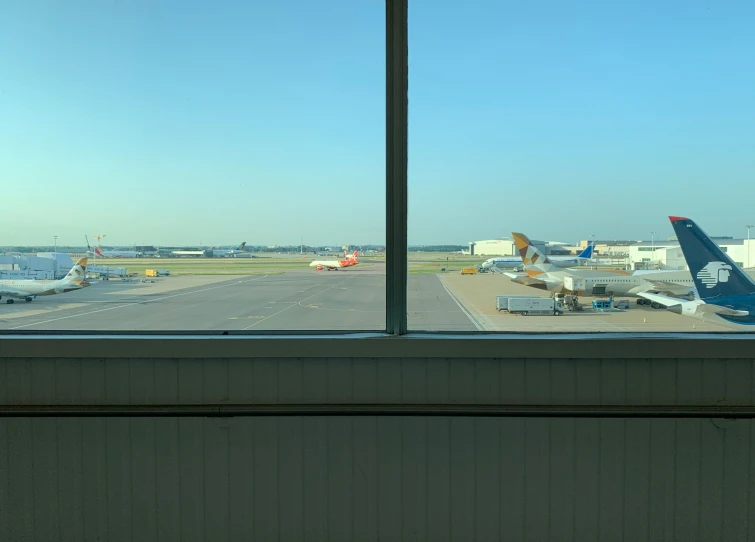 an airport is seen through a window with a view to planes on the tarmac