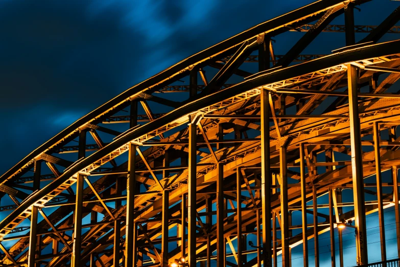 a plane flying over a steel bridge with a full moon in the background