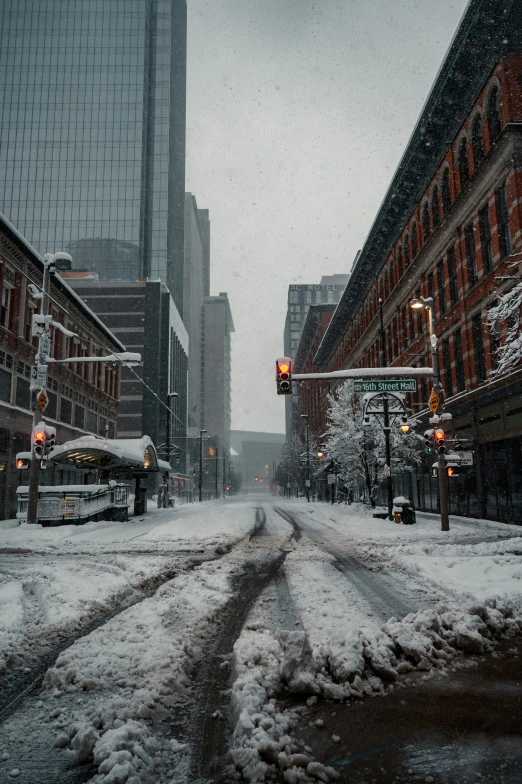 the snow covered street in the city has many buildings