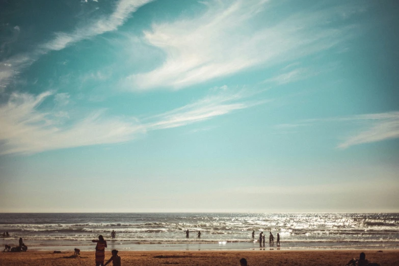 a group of people standing on top of a sandy beach