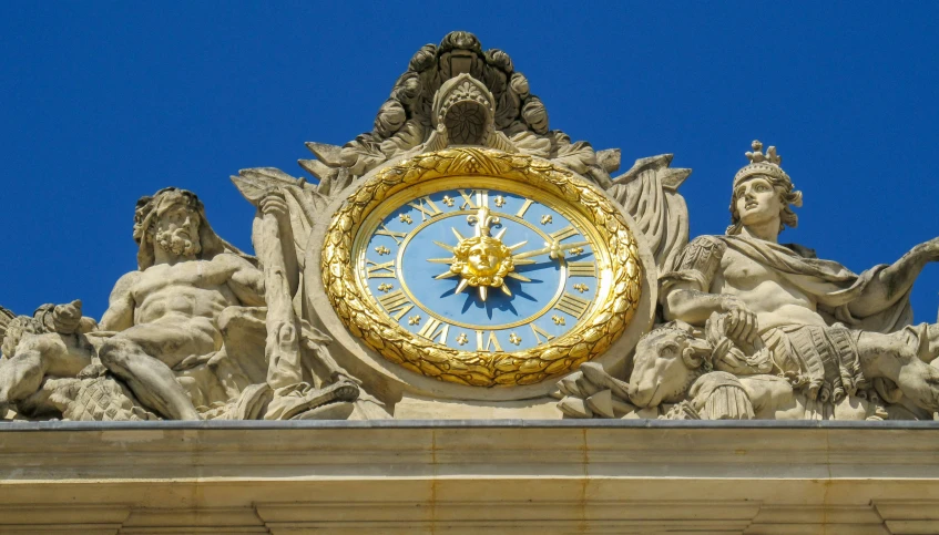 a very large clock with statues and angels on it