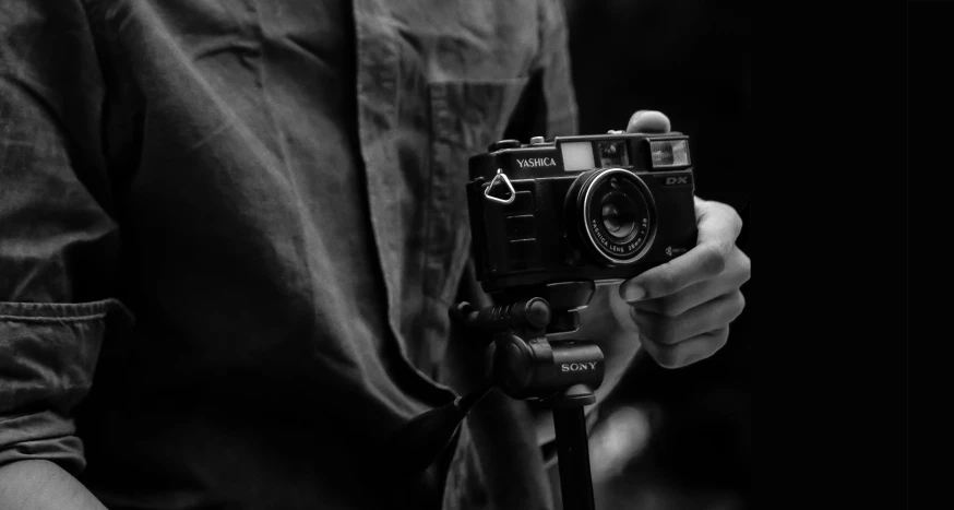 black and white pograph of man holding a camera