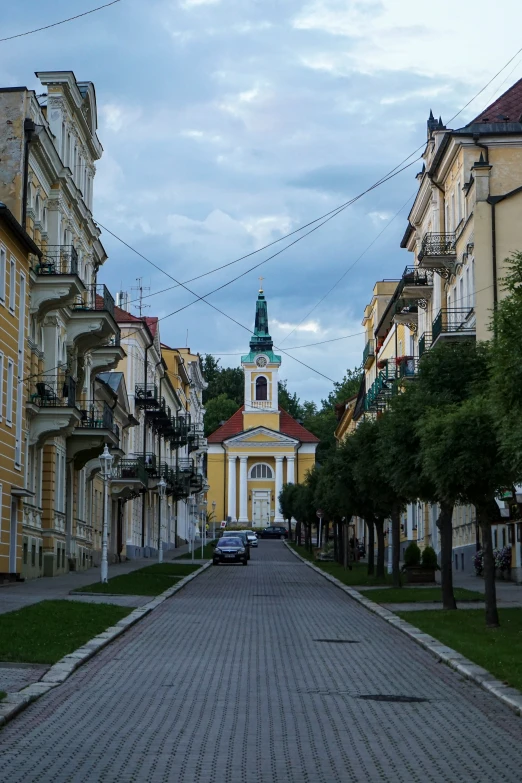 a small city street with a church in the background