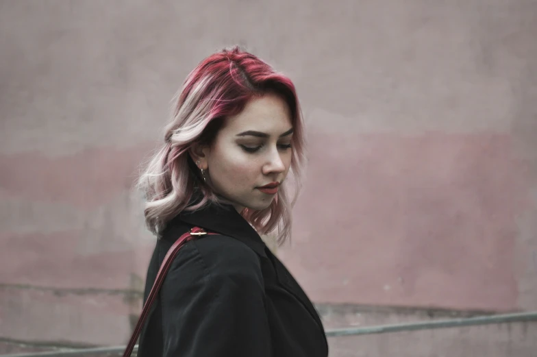 a young woman with pink hair walks by