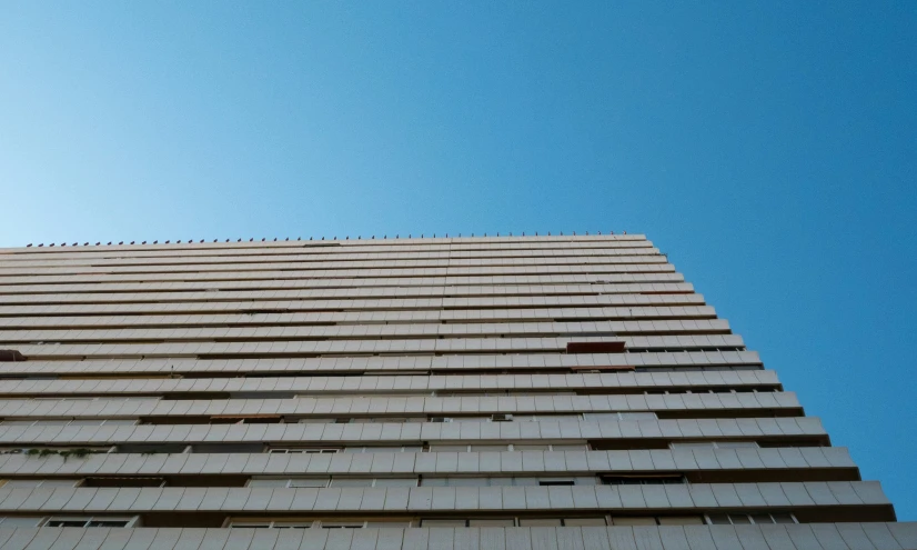 a tall building with many windows under a blue sky