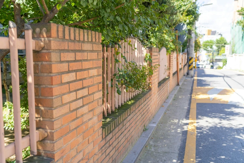 a red brick wall with an iron fence around it