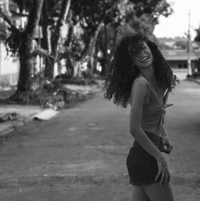 a young black woman is standing on the street with her arm over her hip