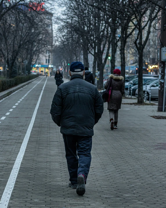 two men walking in the rain down the street