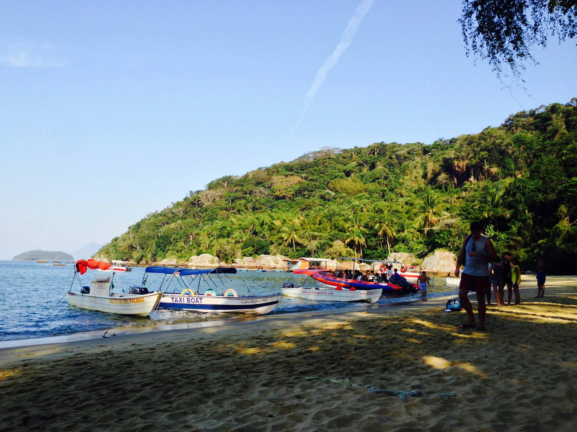 boats parked at the shore of a tropical beach