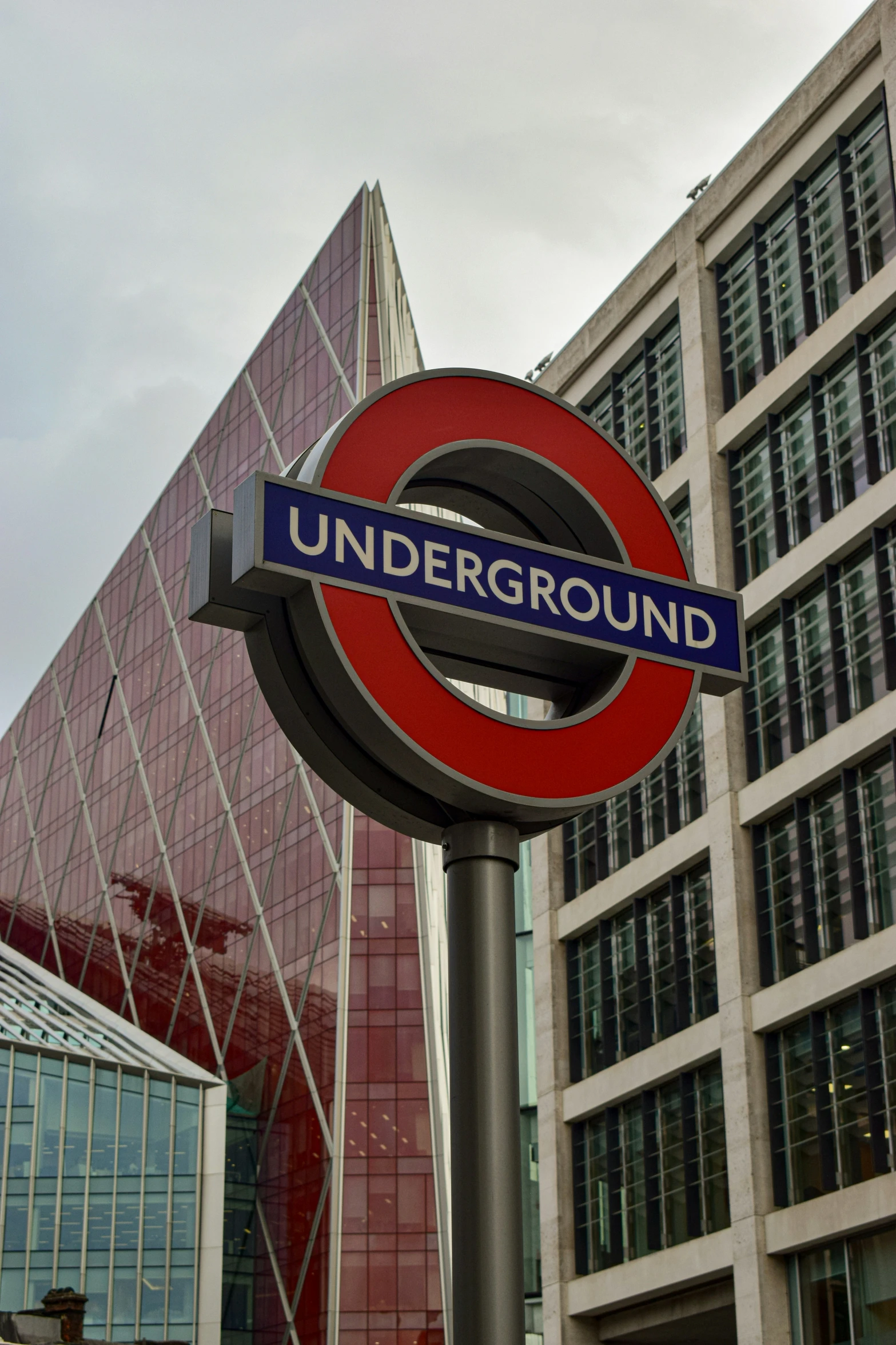 a red and blue sign that says underground near buildings