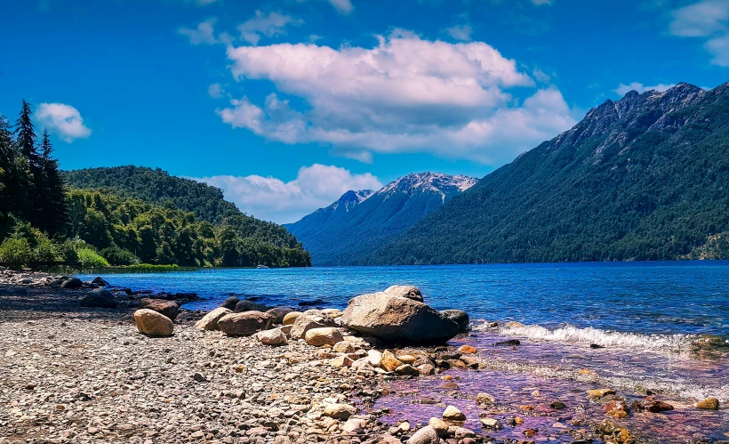 two rocky shore line with mountains in background