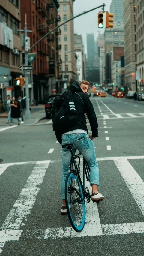 a man riding a blue bicycle through an intersection