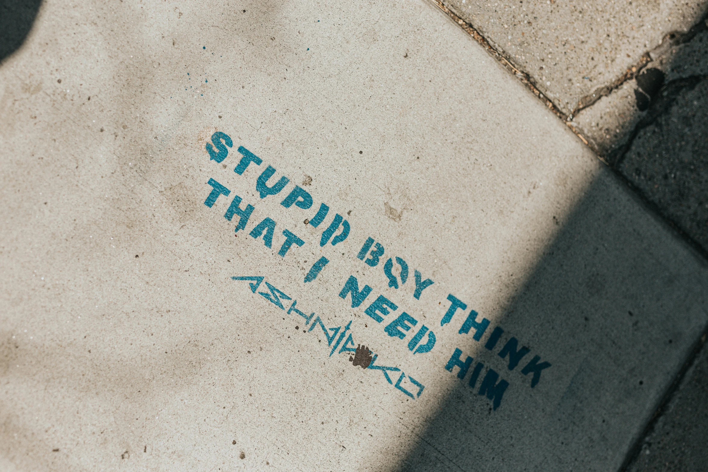 a sidewalk with some blue writings on it