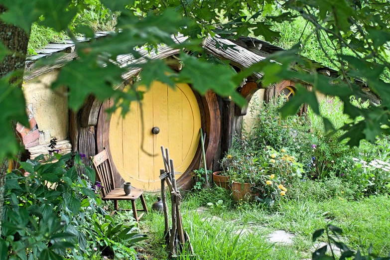 a yellow hobb door surrounded by vegetation in a green meadow