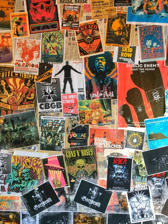 there is an image of an assortment of concert posters on a wall