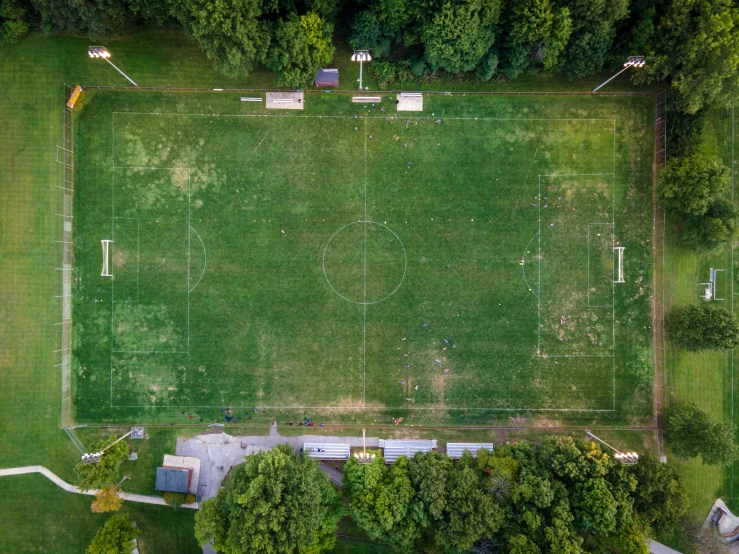 a green soccer field with several posts and goal posts on it