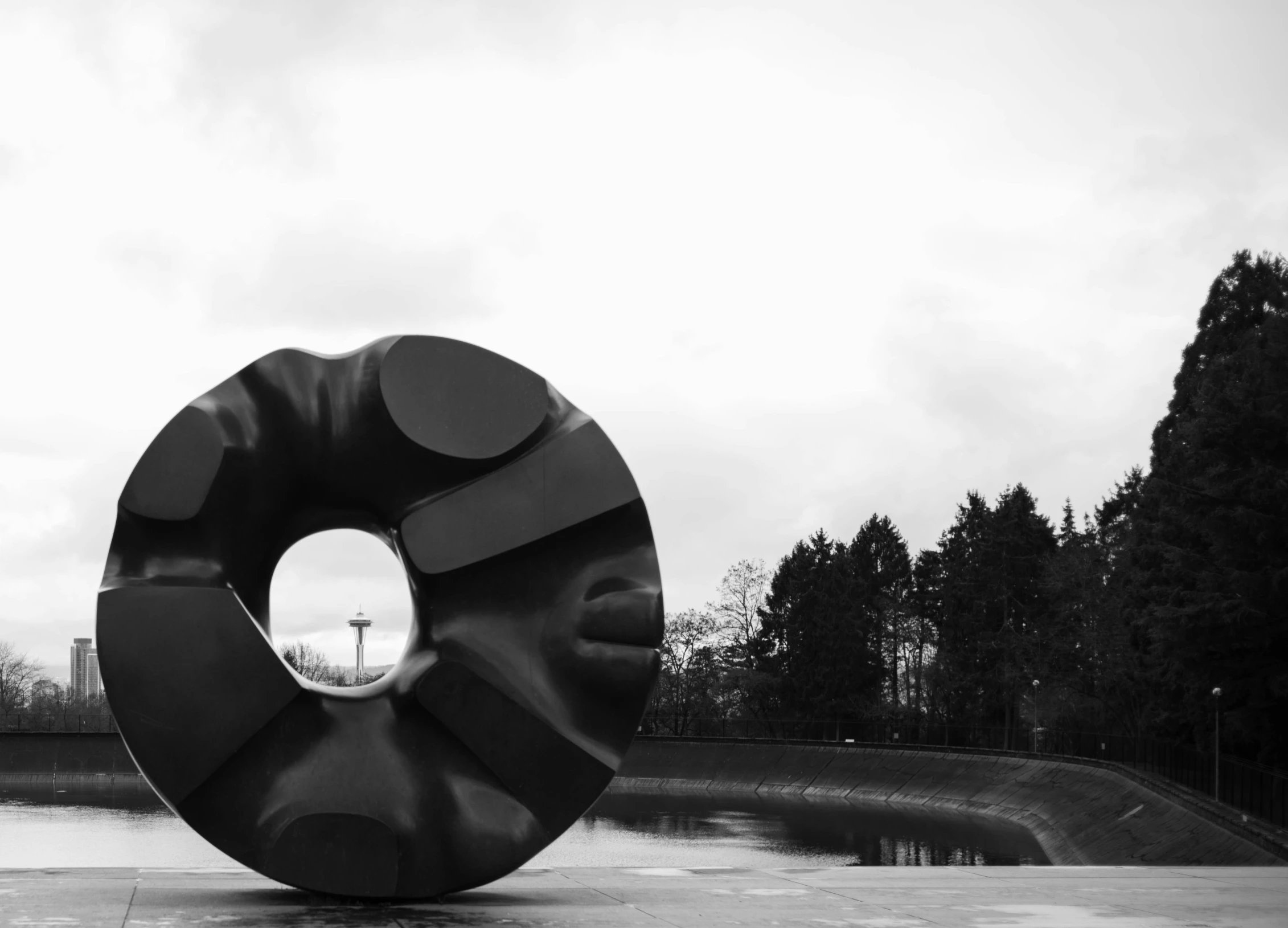 a black and white po of a sculpture in front of a water feature