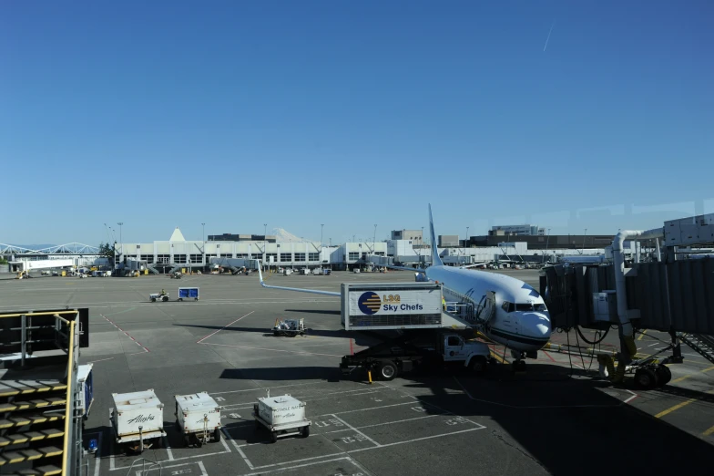 some people stand around at an airport and a plane