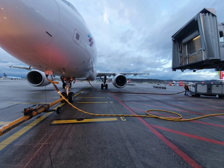 a commercial airplane and its tow rope are connected to the jetway