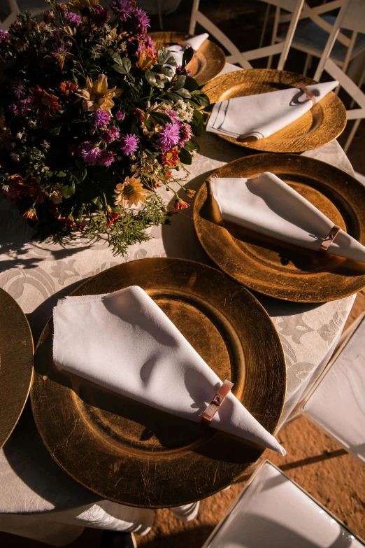 place settings set up on the ground for a dinner party