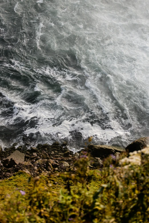 the man is standing alone by the rough ocean