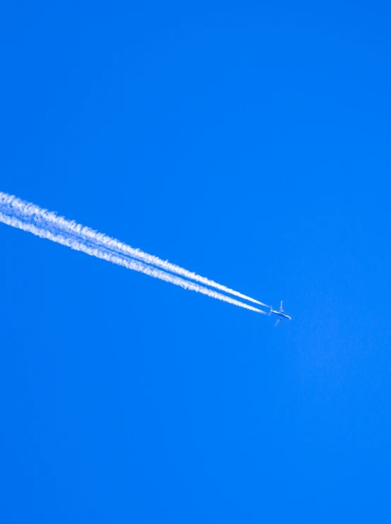 an airplane in the air leaving a trail