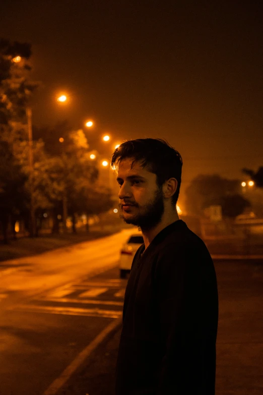 a man is standing on the sidewalk in the dark