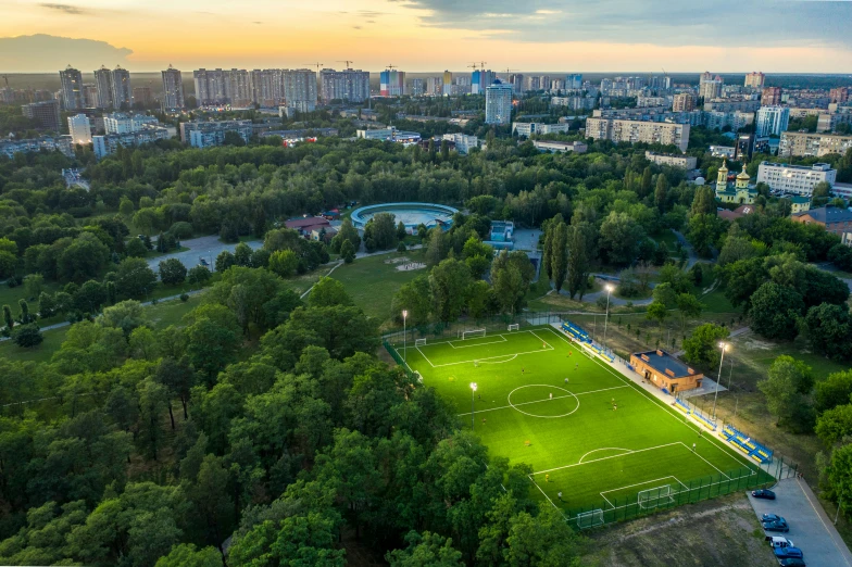 a soccer field in the middle of a city park with lots of green grass