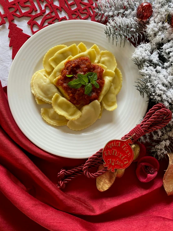 a plate of ravioli on a table with a red napkin