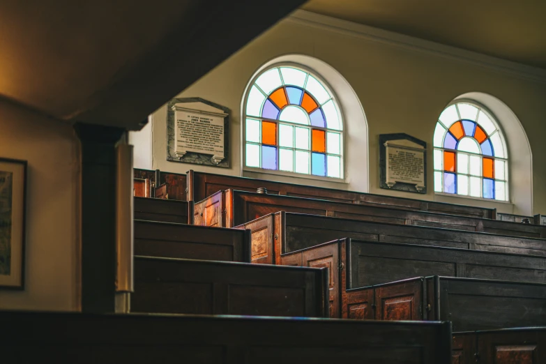 a church pew has wooden pews with stained glass