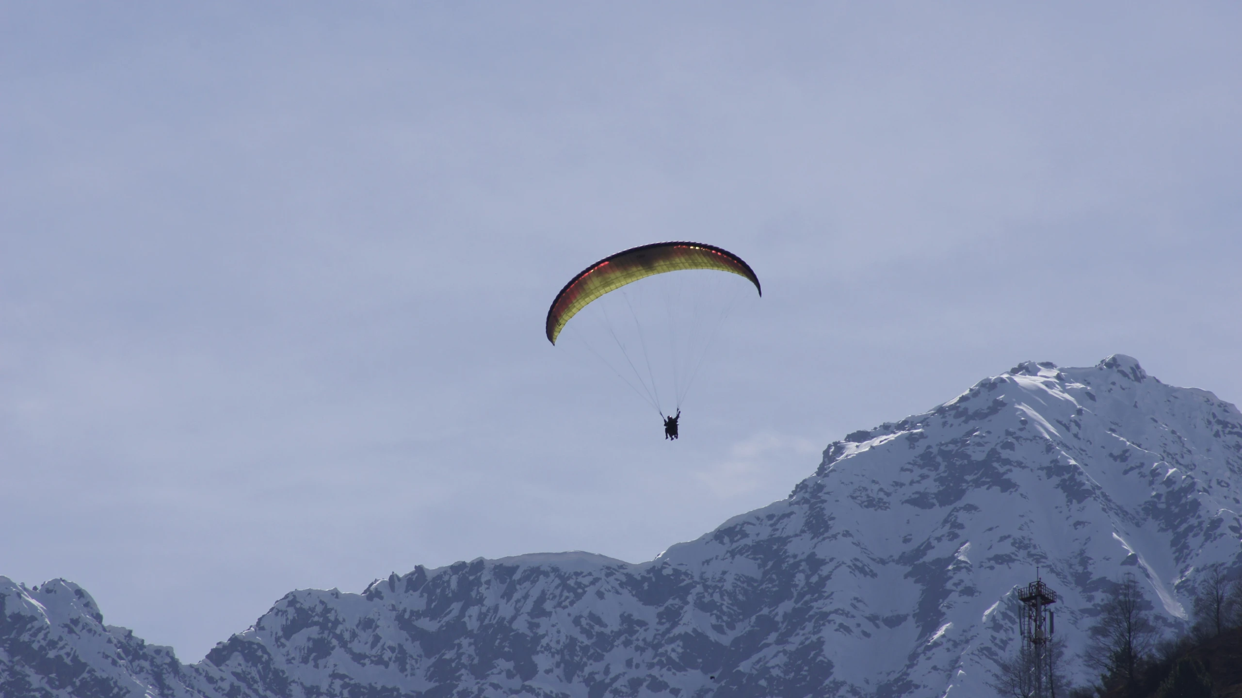 a man in a parachute flying in the sky