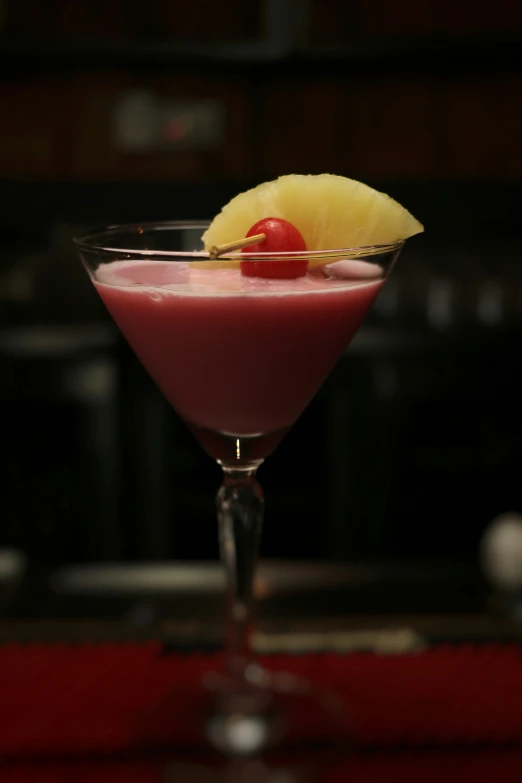 a small drink garnished with a cherry and a pineapple