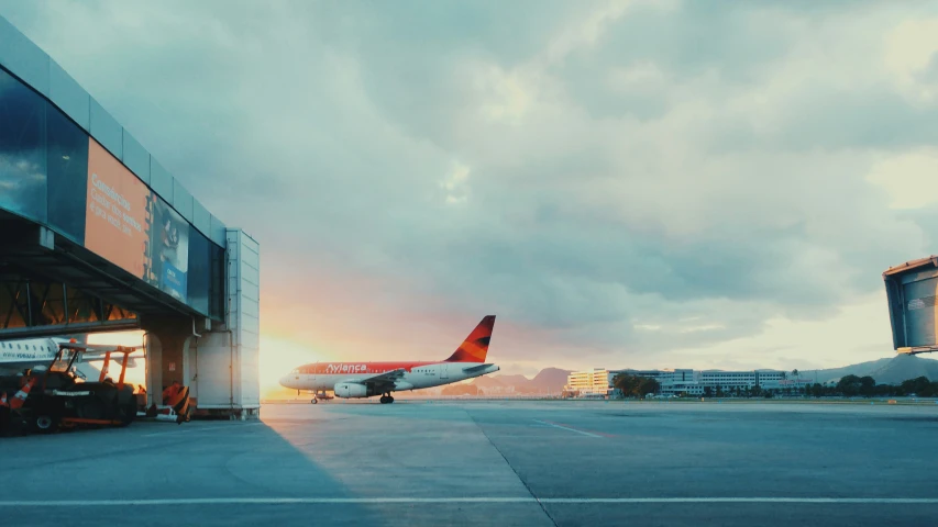 a commercial airplane on the runway outside of an airport terminal