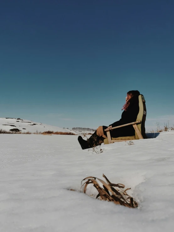 a man that is sitting down in the snow