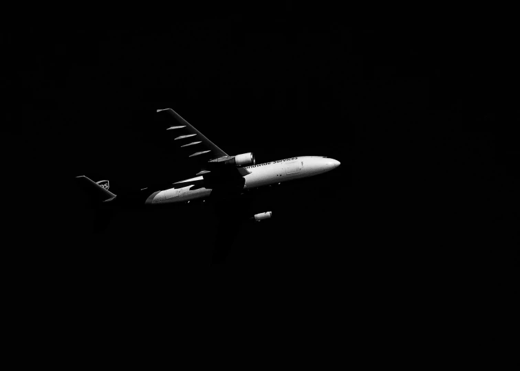 a very big plane flying in the dark sky