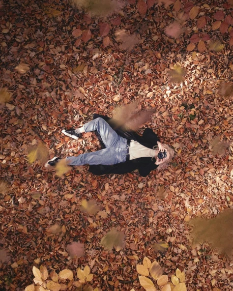 a man is standing on a pile of leaves