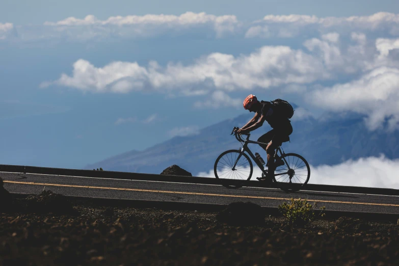 a bicyclist in a helmet riding on the side of a road