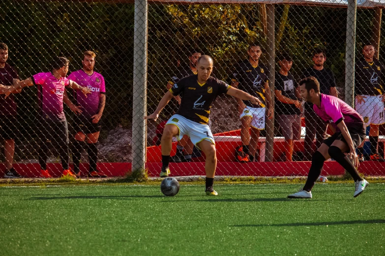 two men on field playing soccer with a crowd in the stands