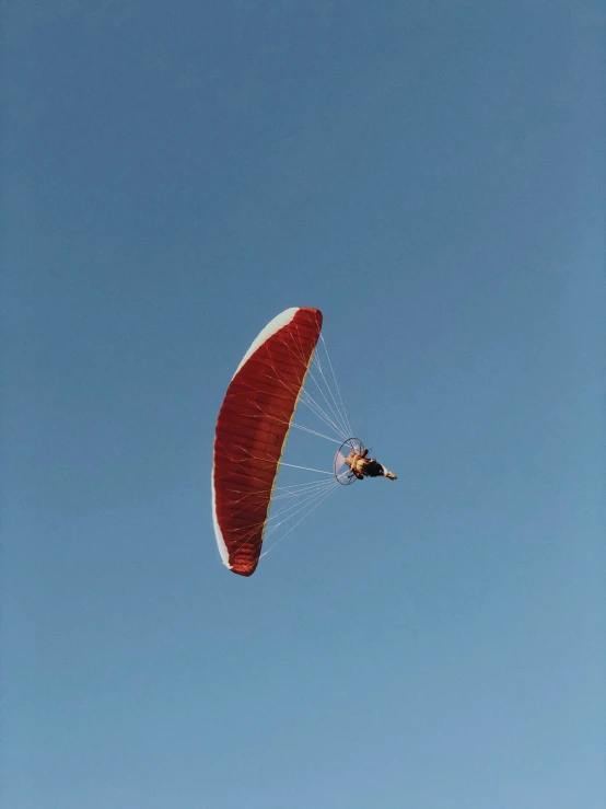 a man flying an orange and white parachute
