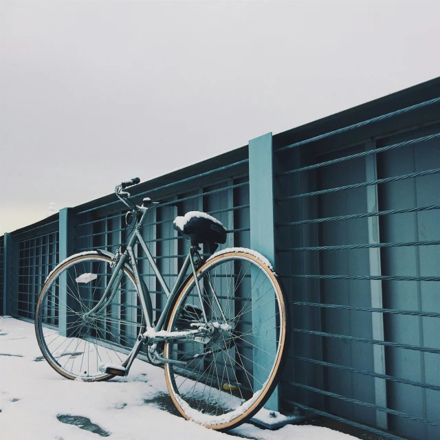 a bike is parked on the fence in winter