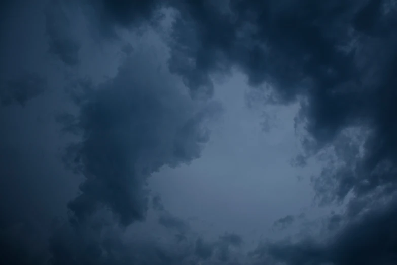 an airplane flying in the distance under a dark sky