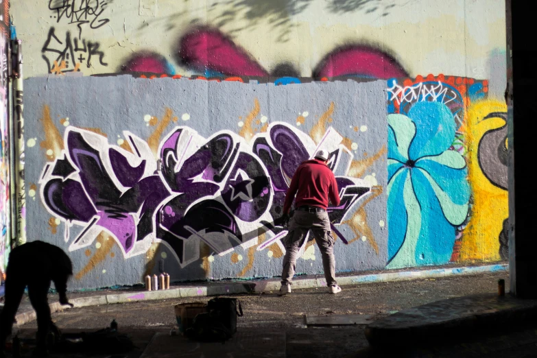 two men are using a paint roller near a wall