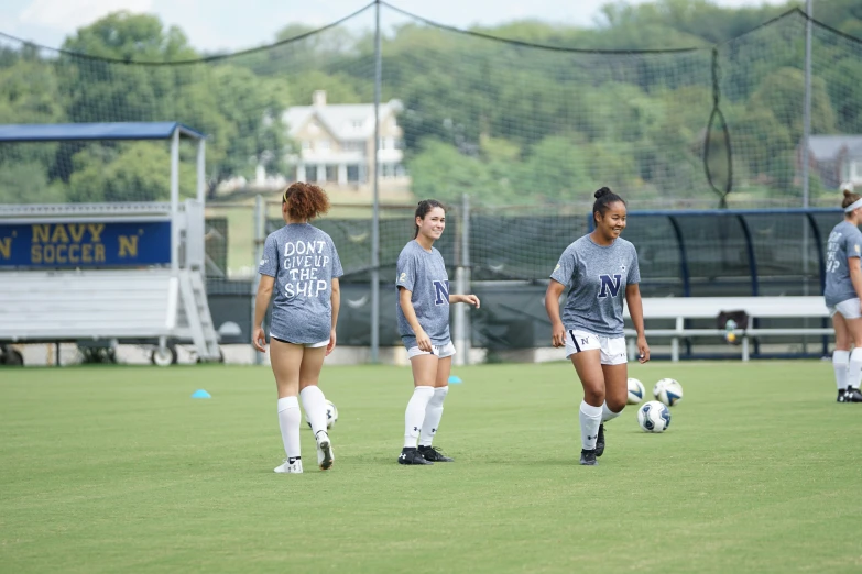 some girls play soccer on an artificial field