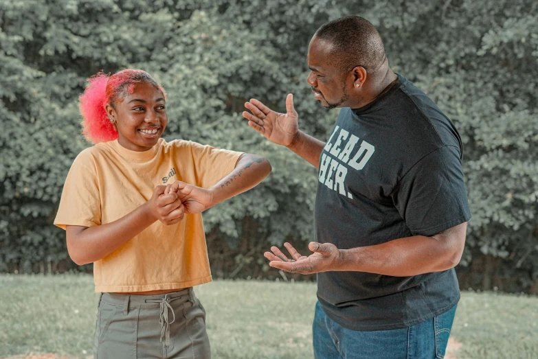 a man and a woman stand together playing frisbee