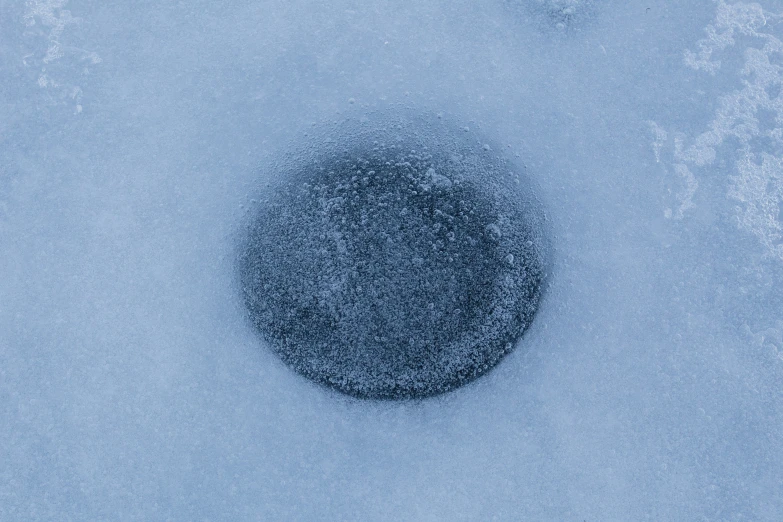 a black object in the snow covered in water