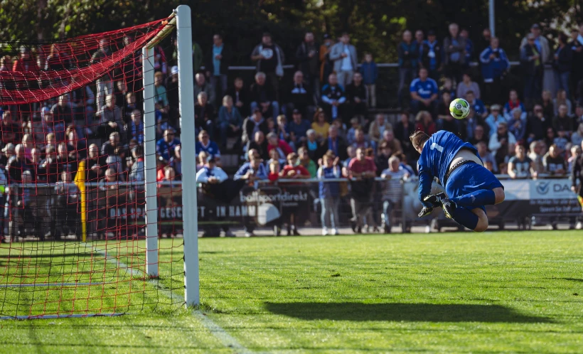 a person jumping up into the air to catch a soccer ball