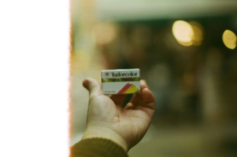 a woman is holding up a small credit card