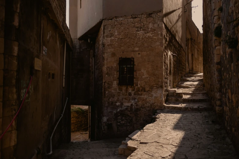 narrow alley with stone houses and walls at sundown